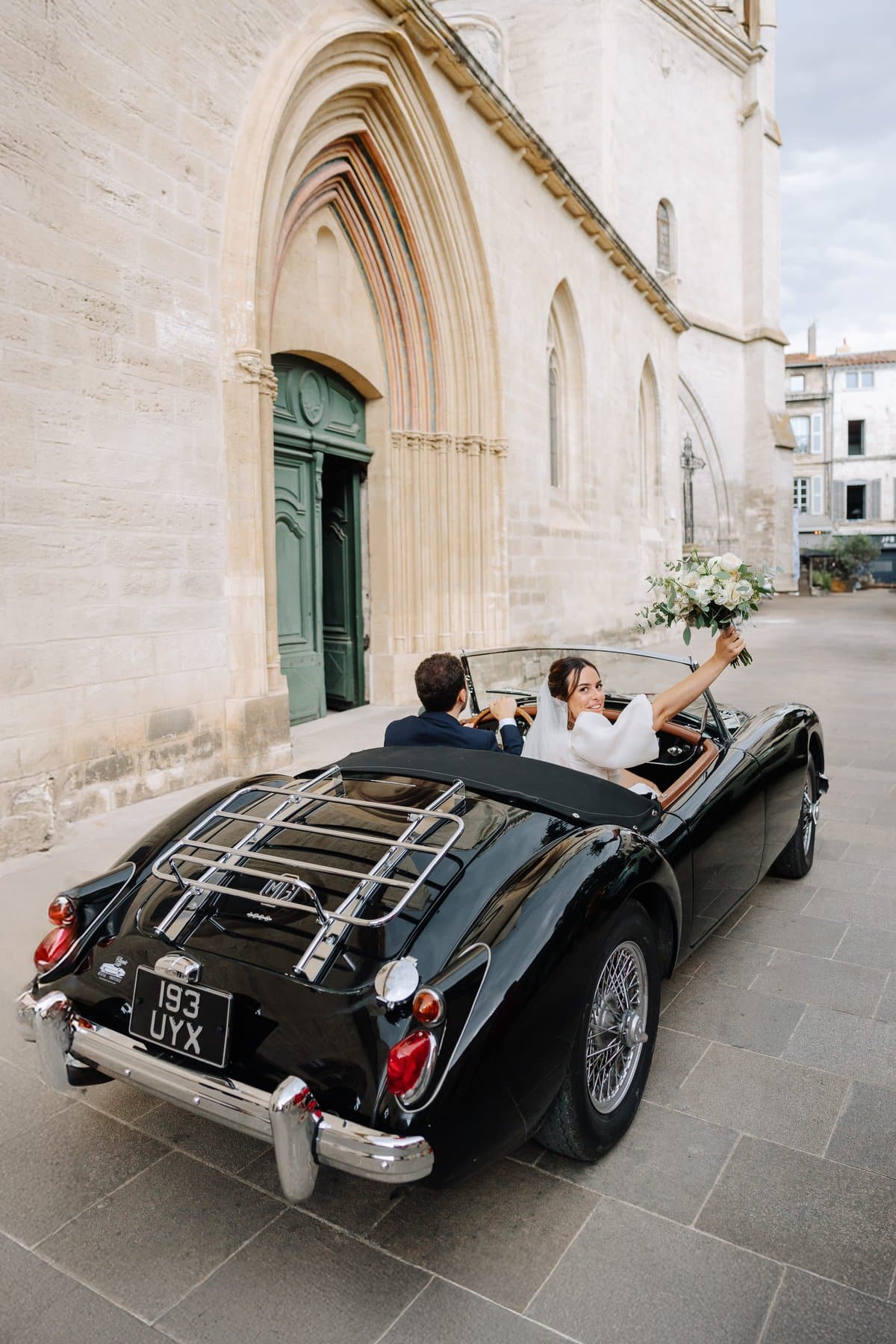 Voiture de collection décapotable devant l'église le jour du mariage