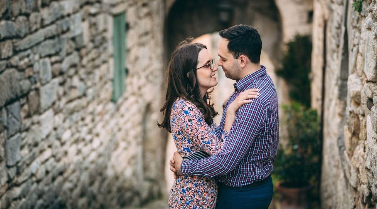 Couple enlacé devant un mur de pierre, séance photo engagement dans le Luberon